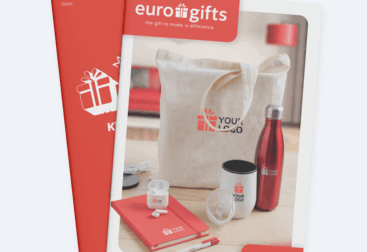 Picture of two stacked brochures. The front one is a promotional gift brochure of Eurogifts with a canvas bag, red steel bottle and notebook on the cover.